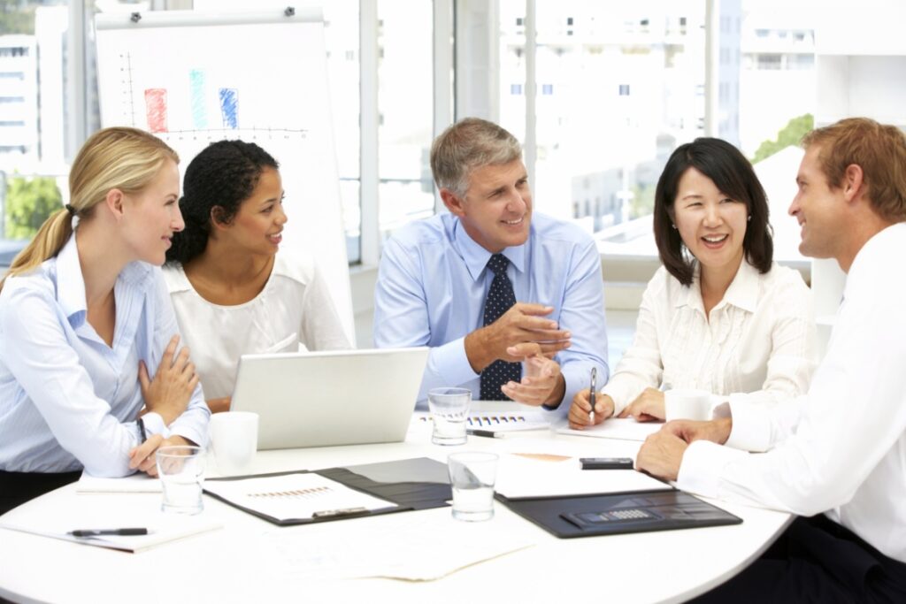 Smiling business people in conversation at a desk