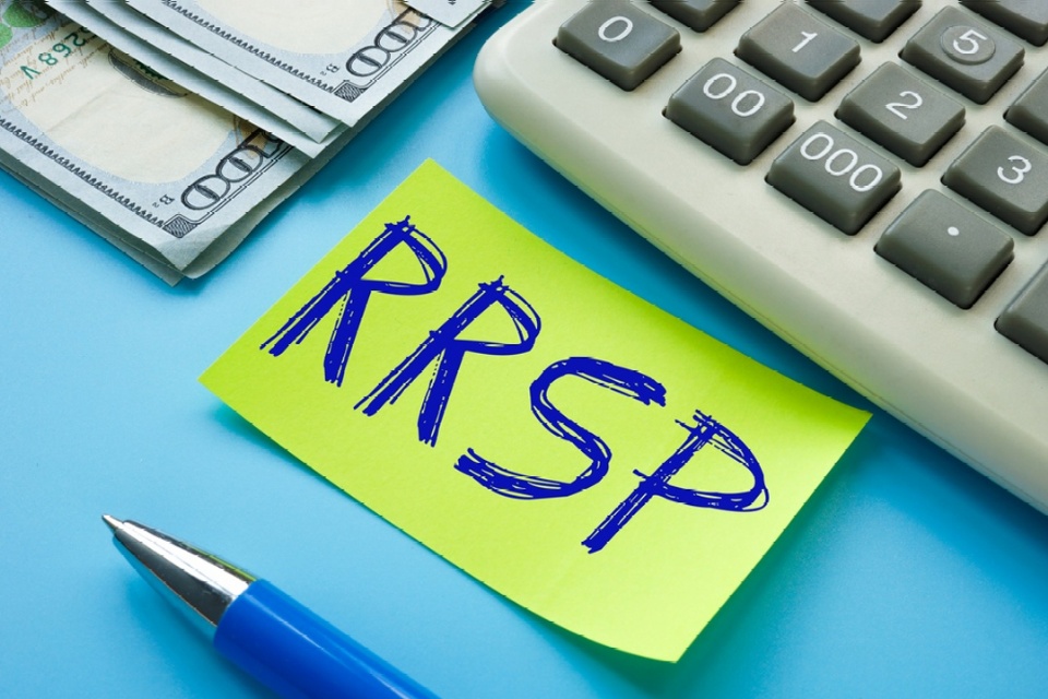 RRSP written with blue pen on yellow sticky by an adding machine and US paper money