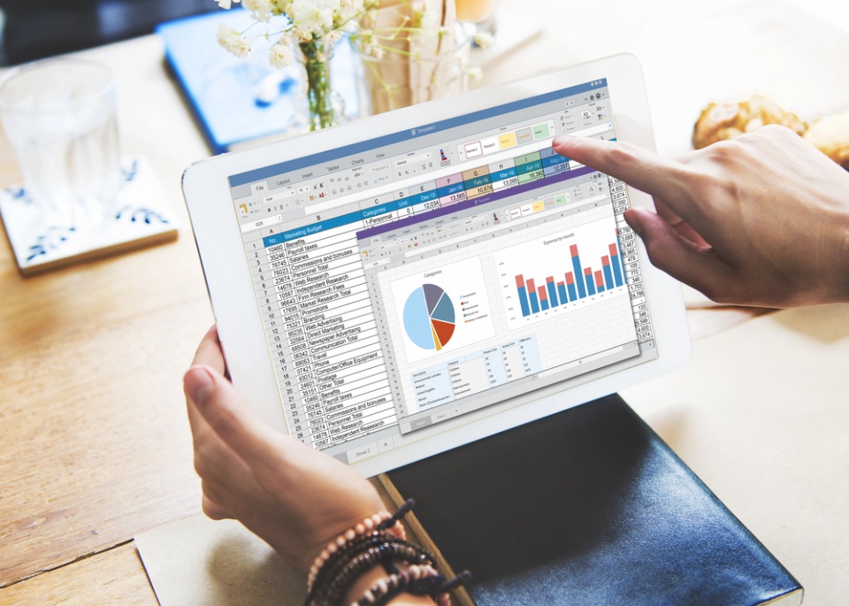 hands holding a tablet with database and charts and graphs